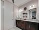 Bathroom featuring double sinks, dark wood cabinetry, granite countertops and modern fixtures at 48 Lark Dr, Placida, FL 33946