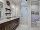 Bathroom featuring double sinks, granite counters, dark wood cabinets, glass shower, and a separate toilet room at 48 Lark Dr, Placida, FL 33946