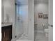 Modern bathroom with a glass-enclosed shower with white tile, pebble floor, and gray tiled floors at 48 Lark Dr, Placida, FL 33946