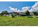Well maintained exterior view of a home showing the manicured lawn, screened in porch, and lush landscaping at 48 Lark Dr, Placida, FL 33946