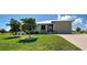 Exterior view of a one story home with a well manicured green lawn and tidy landscaping at 48 Lark Dr, Placida, FL 33946