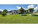 Exterior view of a house showing the screened in porch, lush lawn and landscaping at 48 Lark Dr, Placida, FL 33946