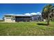 Exterior of home showing screened in porch and lush green back lawn at 48 Lark Dr, Placida, FL 33946