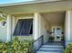 Inviting front porch with tiled steps, black railing, and potted plants near a decorative glass front door at 48 Lark Dr, Placida, FL 33946