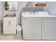 Bright laundry room features washer, dryer, sink and storage, adding functionality to the home at 48 Lark Dr, Placida, FL 33946