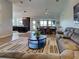 Open living room featuring a plush couch, modern rug, and a view into the bright, eat-in kitchen at 48 Lark Dr, Placida, FL 33946