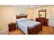 Well lit bedroom with a wood bed frame, wood floors, ceiling fan, and matching wood dresser at 528 Barcelona Ave # 216, Venice, FL 34285
