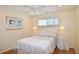 Comfortable bedroom with a queen bed, wood floors, ceiling fan, and neutral colored walls at 528 Barcelona Ave # 216, Venice, FL 34285