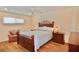 Well lit bedroom with a wood bed frame, wood floors, matching end tables, and ceiling fan at 528 Barcelona Ave # 216, Venice, FL 34285