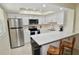 This kitchen features stainless steel appliances, white cabinets, and a breakfast bar with seating for two at 528 Barcelona Ave # 216, Venice, FL 34285