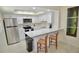 Modern kitchen with white cabinetry, stainless steel appliances, and a breakfast bar at 528 Barcelona Ave # 216, Venice, FL 34285