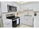 A full view of kitchen features modern stainless steel oven, microwave and undermount sink at 528 Barcelona Ave # 216, Venice, FL 34285