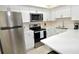 Bright kitchen features stainless appliances, white cabinets and countertops plus bar seating area at 528 Barcelona Ave # 216, Venice, FL 34285