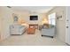 Bright living room featuring comfortable seating, tile flooring, and a large television at 528 Barcelona Ave # 216, Venice, FL 34285