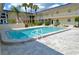 Community swimming pool area surrounded by pavers, lush landscaping, and well maintained exterior at 528 Barcelona Ave # 216, Venice, FL 34285