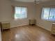 Bedroom featuring two windows, wood-look floors, and matching nightstands at 529 Cervina S Dr, Venice, FL 34285