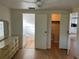 Bedroom featuring doors to an ensuite bath, closet, wood look floors, and ceiling fan at 529 Cervina S Dr, Venice, FL 34285