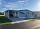 Charming single-story home with light blue siding, awnings, covered carport, and well-maintained landscaping at 529 Cervina S Dr, Venice, FL 34285