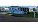 Well-maintained blue home featuring a cozy screened-in porch and manicured lawn, perfect for relaxing outdoors at 529 Cervina S Dr, Venice, FL 34285