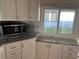 Well-lit kitchen featuring modern microwave, granite countertops, and crisp white cabinetry at 529 Cervina S Dr, Venice, FL 34285
