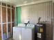 Laundry room featuring exposed framing, washer, dryer, and water heater at 529 Cervina S Dr, Venice, FL 34285