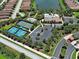 Aerial view showcasing the community's amenities, including the clubhouse, pool, tennis courts, and parking areas at 5832 Semolino St, Nokomis, FL 34275