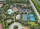 Aerial view featuring the community's tennis courts, swimming pool, playground, clubhouse, parking, and green spaces at 5832 Semolino St, Nokomis, FL 34275
