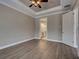 Spacious bedroom featuring hardwood floors, a decorative ceiling fan, crown molding, and ensuite bath at 5832 Semolino St, Nokomis, FL 34275