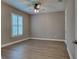 Bright bedroom features wood-look floors, ceiling fan, and shuttered windows for a cozy, modern living space at 5832 Semolino St, Nokomis, FL 34275