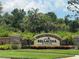 Stone monument sign welcomes visitors to Bellacina by Casey Key, with lush landscaping and a manicured lawn at 5832 Semolino St, Nokomis, FL 34275
