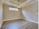 Empty dining room featuring wood floors, an elegant hanging light fixture, and trim that matches the ceiling at 5832 Semolino St, Nokomis, FL 34275