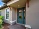 Elegant front door with decorative glass and sidelight, complemented by stone accents and manicured landscaping at 5832 Semolino St, Nokomis, FL 34275