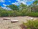 Outdoor game area featuring cornhole boards, surrounded by lush greenery and a well-maintained patio at 5832 Semolino St, Nokomis, FL 34275