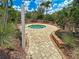 Inviting outdoor hot tub with brick paved walkway, surrounded by lush landscaping and tropical foliage at 5832 Semolino St, Nokomis, FL 34275