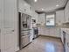 A beautifully appointed kitchen featuring a stainless steel refrigerator, matching appliances and white cabinetry at 5832 Semolino St, Nokomis, FL 34275
