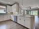 Kitchen view boasting stainless steel appliances, ample counter space, white cabinets, and light gray subway tile backsplash at 5832 Semolino St, Nokomis, FL 34275