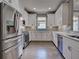 Kitchen view with stainless steel appliances, white cabinets, light countertops, and light gray subway tile backsplash at 5832 Semolino St, Nokomis, FL 34275