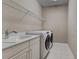 Laundry room with sink, granite countertops, modern washer and dryer, and wire rack shelving at 5832 Semolino St, Nokomis, FL 34275