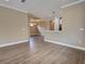 Open-concept living and dining room space featuring hardwood floors and contemporary lighting at 5832 Semolino St, Nokomis, FL 34275
