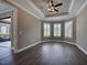 Empty main bedroom featuring dark wood floors, crown molding, a ceiling fan, and bay windows with white shutters at 5832 Semolino St, Nokomis, FL 34275