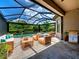 Covered patio with comfortable seating, a dining area, and a built-in grill overlooking a screened-in pool and garden at 5832 Semolino St, Nokomis, FL 34275