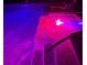 In-ground pool with beautiful colorful lighting at night with a convenient handrail at 5832 Semolino St, Nokomis, FL 34275