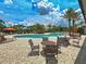 Scenic pool area with comfortable lounge chairs and tables, shaded by umbrellas and surrounded by palm trees at 5832 Semolino St, Nokomis, FL 34275