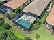 Aerial shot of a screened-in pool, surrounded by manicured landscaping, adjacent to a home with a tile roof at 5832 Semolino St, Nokomis, FL 34275