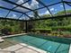 Lovely pool with covered screened-in lanai, gorgeous plantings, and travertine pool deck at 5832 Semolino St, Nokomis, FL 34275