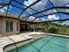 Backyard pool is enclosed in a screened lanai with a covered patio, and lush landscaping at 5832 Semolino St, Nokomis, FL 34275