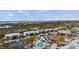 Aerial view showcasing a community with a pool, pond, tennis courts, and well-maintained buildings surrounded by lush landscaping at 6800 Placida Rd # 280, Englewood, FL 34224