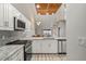 Modern kitchen with stainless steel appliances, granite countertops, white cabinetry, and unique ceiling detail at 6800 Placida Rd # 280, Englewood, FL 34224