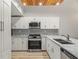 Modern kitchen featuring white cabinetry, stainless steel appliances, granite countertops, and unique ceiling detail at 6800 Placida Rd # 280, Englewood, FL 34224