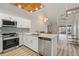 Modern kitchen with stainless steel appliances, granite countertops, white cabinetry, and unique ceiling detail at 6800 Placida Rd # 280, Englewood, FL 34224